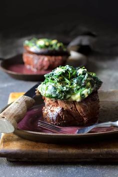 two steaks with broccoli and cheese on a plate