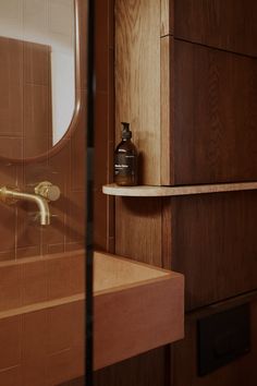 a bathroom with a sink, mirror and wooden cabinet in the backround area