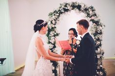 a bride and groom holding hands during their wedding ceremony