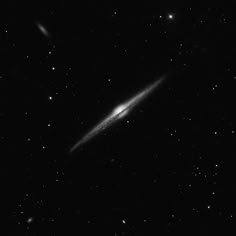 a black and white photo of a very large object in the sky with stars around it