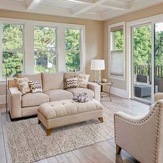 a living room filled with furniture and lots of windows