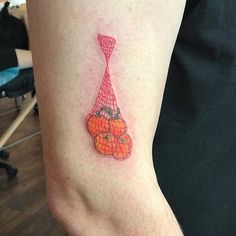 a person with a tattoo on their arm that has oranges and a tie on it