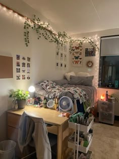 a dorm room with lights and pictures on the wall above the bed, along with other items