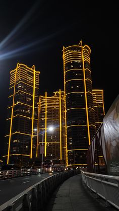 the city is lit up at night with bright lights and tall buildings in the background