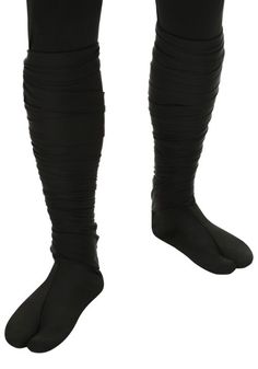 the legs and ankles of a person wearing black socks with ruffled sleeves, one leg in