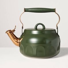 a green tea kettle with a gold handle