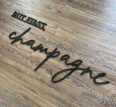 a wooden floor with metal words that spell out the word champagne