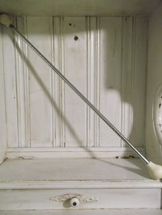 an old clock sitting on top of a white dresser