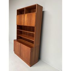 a wooden bookcase sitting next to a white wall