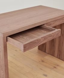 a wooden desk with one drawer open