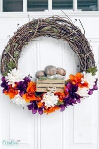 a wreath with flowers and eggs on it