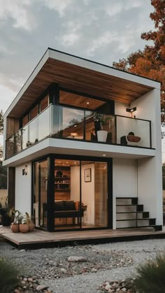 a modern house with an open floor plan and glass walls on the top level is shown