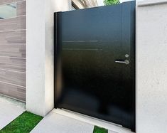 an entrance to a modern home with grass in the front yard