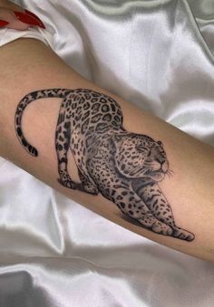 a black and white tattoo of a leopard on the arm