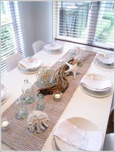 the table is set with white dishes and place settings