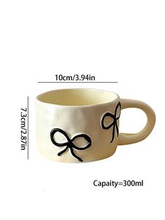 a coffee cup with black bows on it and measurements for the mugs in front