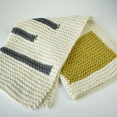 two knitted mittens sitting next to each other on top of a white table