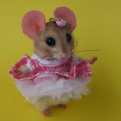 a mouse dressed up in a pink and white dress