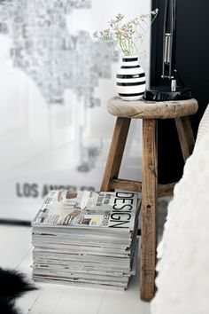 a stack of magazines sitting on top of a wooden stool