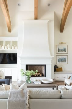 a living room filled with furniture and a fire place in front of a tv mounted on a wall