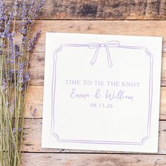 some lavender flowers sitting on top of a wooden table next to a white paper with the words time to the knot