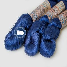 three skeins of blue yarn sitting next to each other on a white surface