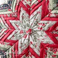 a red and white quilted snowflake on top of a table cloth covered pillow