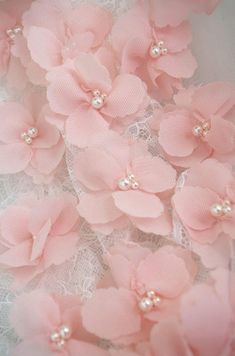 pink flowers and pearls are on the lace