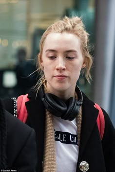 a woman with headphones on walking down the street