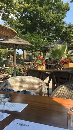 an outdoor dining area with tables, chairs and umbrellas