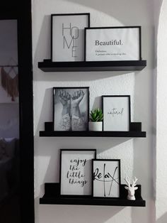 three black shelves with pictures and frames on them