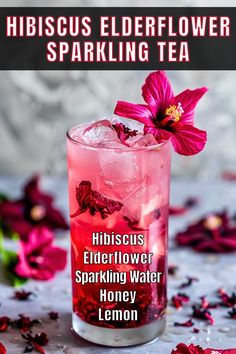 hibiscus elderflower sparkling tea in a glass with pink flowers on the side