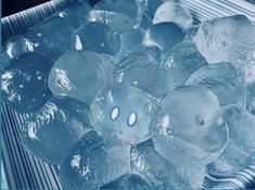 ice cubes in a metal container filled with water and lit up by the light