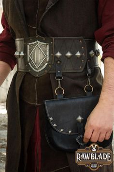 The Aragon Belt is a striking accessory designed for both functionality and style. Featuring an ornate shield centerpiece and studded detailing, this high-quality leather belt is perfect for LARP, Renaissance Faires, and historical reenactments. The belt includes a convenient pouch, ideal for carrying essentials while maintaining an authentic look. Adjustable for a comfortable fit, it is a must-have for warriors, adventurers, and medieval enthusiasts seeking to complete their costume with a touc Archery Clothing, Medieval Belt, Armor Clothing, Steampunk Leather, Historical Reenactment, Leather Armor, Armors, Aragon, Larp