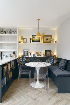 a living room filled with furniture and lots of books on the shelf above it's corner