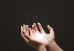 two hands reaching up towards the sky with small stars coming out of their palms