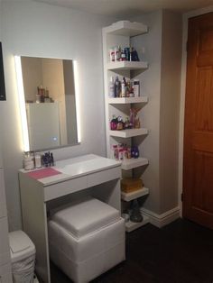 a bathroom with a sink, mirror and shelves on the wall next to a toilet