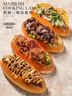 three hot dogs on buns with meat and lettuce in them, sitting on a table