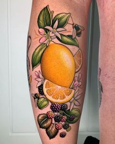 an orange with leaves and flowers on the legs is shown in this tattoo design by person