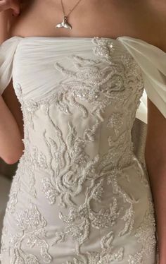 the back of a woman's wedding dress with an off - shoulder and beading