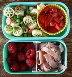 two plastic trays filled with food on top of a wooden table next to each other