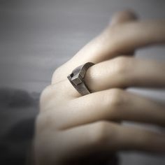 a person's hand with a ring on it