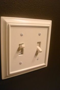 an electrical outlet with two white switches