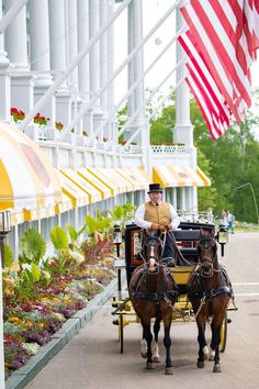 two brown horses pulling a carriage with a man in top hat and coat on it