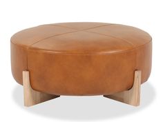 a brown leather ottoman with wooden legs