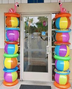 the entrance to an office building decorated with brightly colored balls and flamingos on top