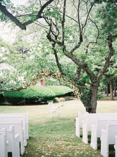 an outdoor ceremony set up with white chairs