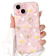 a woman's hand holding a pink phone case with flowers on it