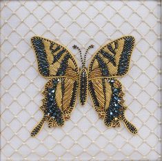 a yellow and black butterfly is on a white background with gold trimmings, it's wings are spread wide