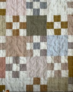 a close up of a quilt made with squares and stripes on it's edges